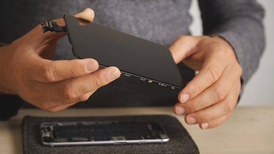Comparação de uma tela de celular antes e depois da troca, na bancada de reparos.